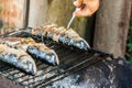 Man checks the fish on the grill for readiness Royalty Free Stock Photo