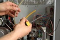 A male checks a gas boiler for home heating. Maintenance and repair of gas heating Royalty Free Stock Photo