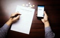 A man checks her account balance on phone. Lack of money, filling out unemployment benefits form.  All screen graphics are made up Royalty Free Stock Photo