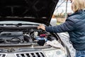 A man checks the oil level in a car engine with an iron dipstick. Technical check of the car