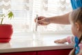 Man checks the purity level of tap water using water TDS meter tool, at home. Device shows 196 ppm of contaminant level, which is