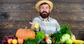 Man cheerful bearded farmer hold corncob or maize wooden background. Farmer with homegrown harvest. Farmer rustic Royalty Free Stock Photo