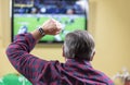 Man cheers for team while watching football game on TV