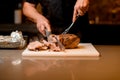 man chef accurate cuts cooked fried meat on white cutting board. Royalty Free Stock Photo