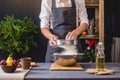 Man chef in a black apron kneading the dough with hands for Christmas baking. Joyful cooking for festive new year table