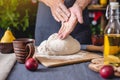 Man chef in a black apron kneads the dough with hands for Christmas baking. Joyful cooking for festive new year table