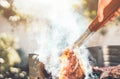 Man chef grilling beef steak at barbecue dinner party outdoor - Close up male hand cooking meat on bbq for family in the garden Royalty Free Stock Photo