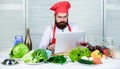 Man chef searching internet recipe cooking food. Chef laptop read culinary recipes. Culinary school. Hipster in hat and Royalty Free Stock Photo