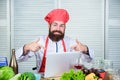 Man chef searching internet recipe cooking food. Elearning concept. Chef laptop read culinary recipes. Culinary school Royalty Free Stock Photo