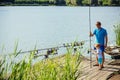 Man and child boy fishing with rods from wooden pier Royalty Free Stock Photo
