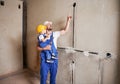 Man and child electricians looking at electrical cable at home.