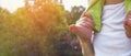 A man with a child on his shoulders. Close-up of barefoot little leg and hand of father on the background of nature Royalty Free Stock Photo