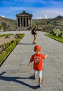 A man with a child near the temple of Garni pagan, a Greek temple in the Republic of Armenia. May 3, 2019. Royalty Free Stock Photo