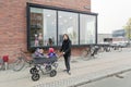 Man and children in a stroller near the windows of a kindergarten