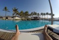 Man chilling at pool legs and foot in Oman Salalah Souly Bay