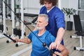 Man chiropractor or osteopath correcting old man patients movements during rehabilitation