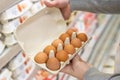 Man chooses and checking quality packing eggs in the supermarket. Shopper in grocery store, supermarket. Royalty Free Stock Photo