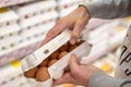 Man chooses and checking quality packing eggs in the supermarket. Shopper in grocery store, supermarket. Royalty Free Stock Photo