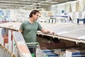 Man chooses floorboard laminate in store Royalty Free Stock Photo