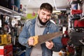 Man chooses hand saw in hardware store Royalty Free Stock Photo