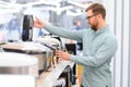 Man choosing crockpot at electric store Royalty Free Stock Photo