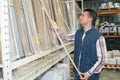 man choosing sawn lumber from store