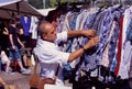 Man choosing shirt on sale of outdoor flea market Royalty Free Stock Photo