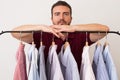 Man choosing shirts in several colors and textures