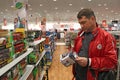 Man choosing toy among wide selection in children`s store. Inside toy shop