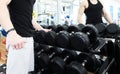 Man choosing weight in a gym. Close up of muscular male hand holding heavy dumbbell during strength workout in gym, copy space. Royalty Free Stock Photo