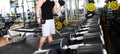 Man choosing weight in a gym. Close up of muscular male hand holding heavy dumbbell during strength workout in gym, copy space. Royalty Free Stock Photo