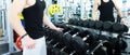 Man choosing weight in a gym. Close up of muscular male hand holding heavy dumbbell during strength workout in gym, copy space. Royalty Free Stock Photo