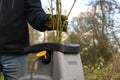 Man is chopping pruning waste with an electric garden shredder, clearing up old branches, copy space Royalty Free Stock Photo