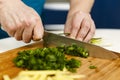 Man chopping spring onions on a wooden board