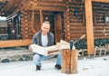 Man chopping wood on snowy yard for a house fireplace with heavy snowflakes background . Winter countryside holidays concept image Royalty Free Stock Photo