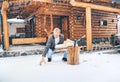 Man chopping wood on snowy yard for a house fireplace with heavy snowflakes background . Winter countryside holidays concept image Royalty Free Stock Photo