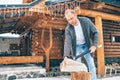 Man chopping wood on snowy yard for a house fireplace with heavy snowflakes background . Winter countryside holidays concept image Royalty Free Stock Photo