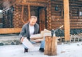 Man chopping wood on snowy yard for a house fireplace with heavy snowflakes background . Winter countryside holidays concept image Royalty Free Stock Photo