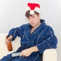 Man in Christmas cap with remote control and beer Royalty Free Stock Photo