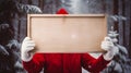 A man in Christmas costume holding blank wooden board for text, Christmas promo