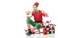 man in christmas elf costume sitting on sleigh, showing thumbs up and holding tablet with ebay app isolated Royalty Free Stock Photo