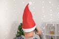 A man in a christmas hat is talking the phone New Year& x27;s Eve. A young man in christmas hat makes greetings phone