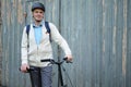 Man with a city bicycle against a gray gate doors Royalty Free Stock Photo