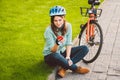 Man and city rolling bicycle, environmentally friendly transport. Beautiful young caucasian woman worker sitting resting on the gr