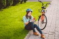 Man and city rolling bicycle, environmentally friendly transport. Beautiful young caucasian woman worker sitting resting on the gr Royalty Free Stock Photo