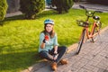 Man and city rolling bicycle, environmentally friendly transport. Beautiful young caucasian woman worker sitting resting on the gr Royalty Free Stock Photo