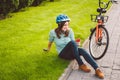 Man and city rolling bicycle, environmentally friendly transport. Beautiful young caucasian woman worker sitting resting on the gr Royalty Free Stock Photo