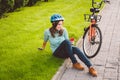 Man and city rolling bicycle, environmentally friendly transport. Beautiful young caucasian woman worker sitting resting on the gr