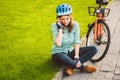 Man and city rolling bicycle, environmentally friendly transport. Beautiful young caucasian woman worker sitting resting on the gr Royalty Free Stock Photo