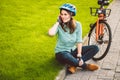 Man and city rolling bicycle, environmentally friendly transport. Beautiful young caucasian woman worker sitting resting on the gr Royalty Free Stock Photo